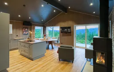 a kitchen with a stove and a table and a fireplace at 4 Bedroom Gorgeous Home In Koppang in Koppang