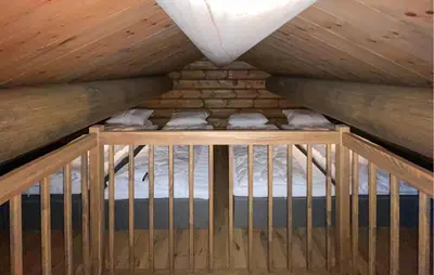 a room with a bed in a wooden attic at Amazing Home In Koppang in Koppang