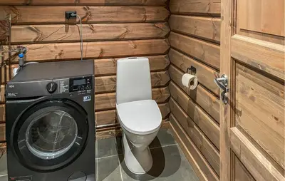 a bathroom with a toilet and a washing machine at Amazing Home In Koppang in Koppang