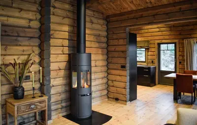 a woodburning stove in a room in a log cabin at Amazing Home In Koppang in Koppang