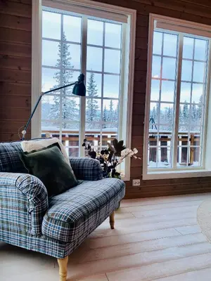 a living room with a couch and a lamp and windows at Beitobygda Getaway ,Nature And Luxury in Beitostøl