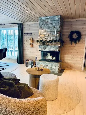 a living room with a stone fireplace and a table at Beitobygda Getaway ,Nature And Luxury in Beitostøl
