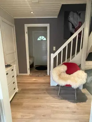 a room with a staircase with a red and white chair at Villa 10 min walk from Ski World Championship in Trondheim