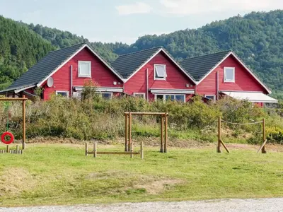 a row of red houses with a group at 4 person holiday home in Sørbøvåg in Sørbø
