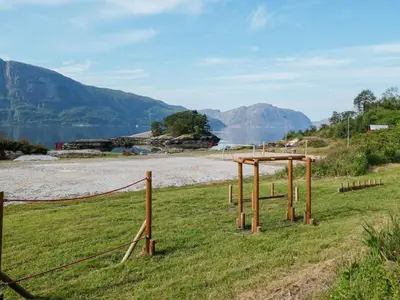 a field with a fence and a body of water at 4 person holiday home in Sørbøvåg in Sørbø