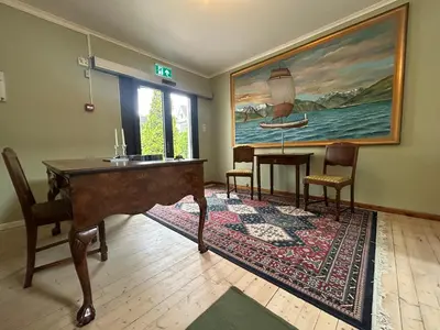 a living room with a piano and a painting at Sognefjord Gjesteheim in Vangsnes