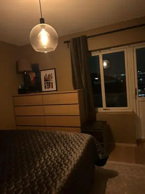 a bedroom with a bed and a window at night at Singsaker Panorama in Trondheim