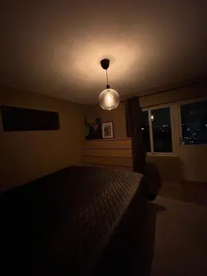 a dark room with a bed and a light at Singsaker Panorama in Trondheim