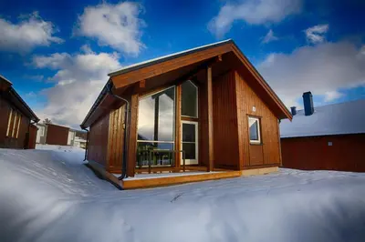 a house with a large window on top of snow at Perfect Base For Skiing And Local Events in Beitostøl