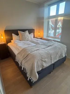 a large bed in a bedroom with a window at Sentrumsnær trivelig leilighet in Bergen