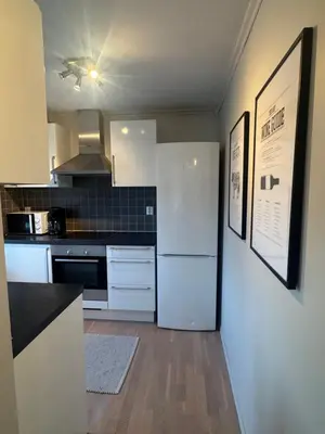 a kitchen with white appliances and a white refrigerator at Sentrumsnær trivelig leilighet in Bergen