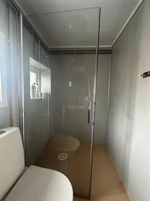 a glass shower in a bathroom with a toilet at Turifoss Camping Cabin 1 in Meråker