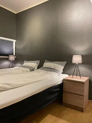 a bedroom with a large bed and a table with a lamp at Geilo sentrumsnær leilighet in Geilo