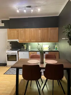 a kitchen with a wooden table and chairs in it at Geilo sentrumsnær leilighet in Geilo