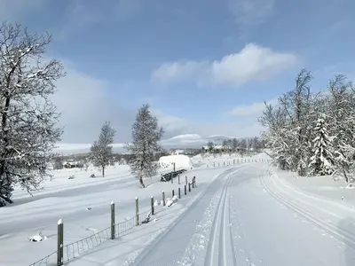 a snow covered road with a fence and trees at Cozy Cabin With Fantastic Mountain Views In Oppheimåsen in Torpo