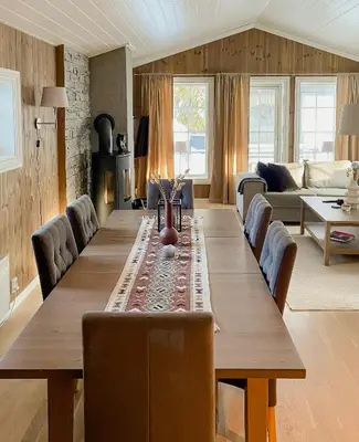 a living room with a wooden table and a couch at Cozy Modern Cabin Near Sjusjøen in Mesnali