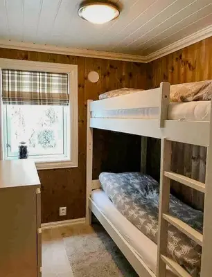 a room with two bunk beds and a window at Cozy Modern Cabin Near Sjusjøen in Mesnali
