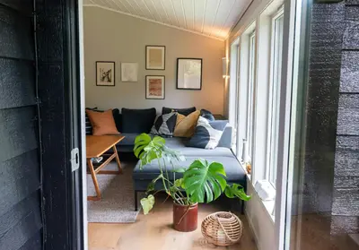 a living room with a couch and a window at Modern And Rustic Cabin With Fjord View In Samnanger in Årland