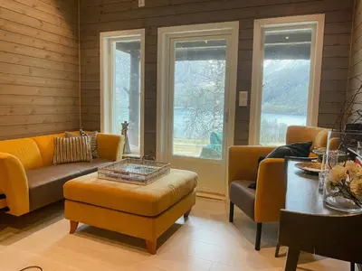 a living room with a couch and a table at Cozy Modern Cabin In West Norway With View in Davik