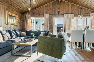 a living room with a blue couch and a table at Charming Treehouse With View In Hafjell in Øyer