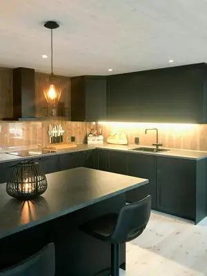 a kitchen with black cabinets and a table and chairs at Large Cabin Near Hardangervidda With Sunny Veranda in Veggli