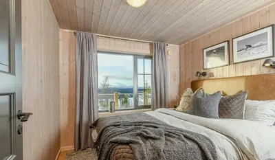 a bedroom with a large bed with a large window at Modern Cabin With Beautiful Design By Gålåvatn in Gålå