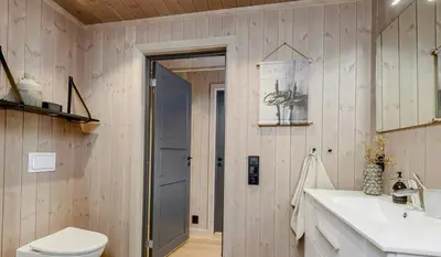 a bathroom with a toilet and a sink and a door at Modern Cabin With Beautiful Design By Gålåvatn in Gålå