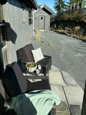 a porch with a chair and a tv on the side of a house at Modern Cabin With Views Of Skeikampen in Svingvoll