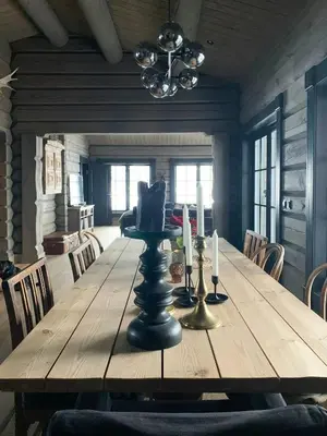 a dining room with a wooden table with two candles at Cozy Log Cabin With A View Over Hedmarken in Løten