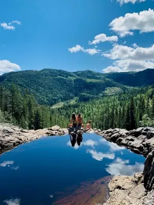 two women sitting on top of a body of water at Luxury Log Cabin By Hardangervidda in Uvdal