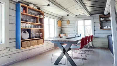 a dining room with a table and red chairs at Idyllic Log Cabin With Ski-Inout At Dagalifjell in Uvdal