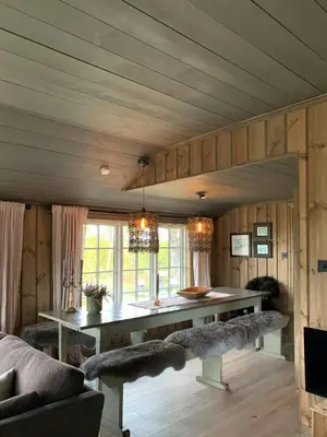 a living room with a table and some chairs at Secluded Mountain Cabin In Rauland With View in Rauland