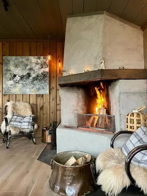 a stone fireplace in a room with a couch and a chair at Secluded Mountain Cabin In Rauland With View in Rauland