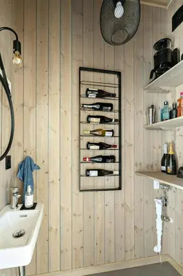 a bathroom with a rack of wine bottles on the wall at Norefjell Cottage With Sauna And Whirlpool in Noresund