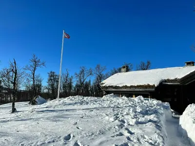 a flag pole on top of a pile of snow at Large Log Cabin, Ski Fun Near Dagali in Dagali