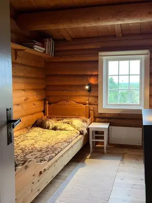 a bedroom with a bed in a wooden wall at Charming Cabin Near Rondane National Park in Venabygd