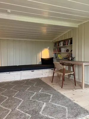 a room with a couch and a table and a book shelf at Charming Cabin Near Rondane National Park in Venabygd