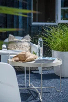 a white coffee table with pillows on a patio at Authentic Cabin Hygge All Year Round At Hafjell in Øyer