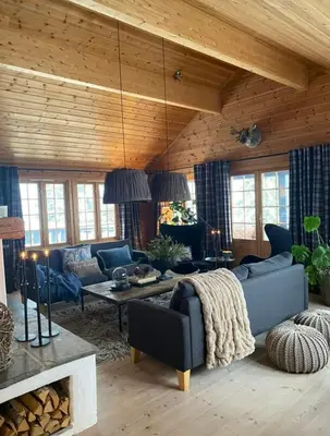 a living room with a blue couch and a table at Authentic Cabin Hygge All Year Round At Hafjell in Øyer
