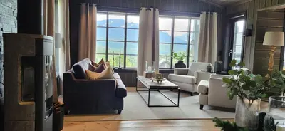 a living room with a couch and chairs and a fireplace at Modern Cabin With Ski Inout In Great Area in Brunstad
