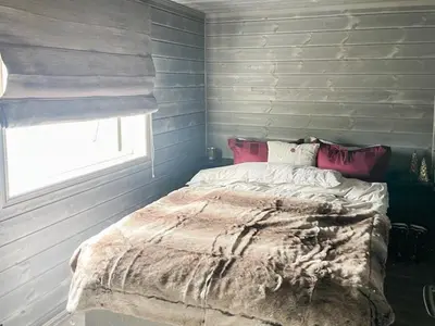 a bed in a bedroom with blue walls and a window at Modern Cabin By Hardangervidda in Garden