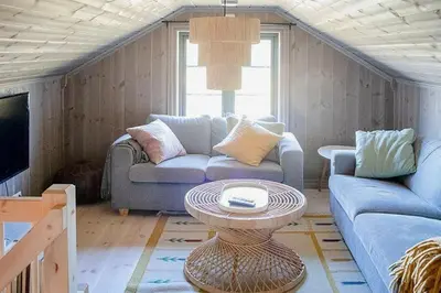 a living room with a couch and a table at Secluded Mountain Cabin In Rauland With View in Brunstad