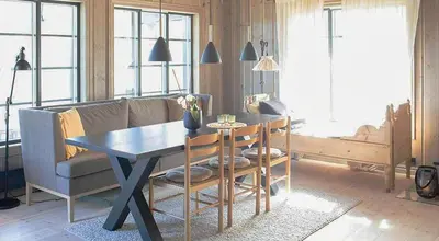 a living room with a table and a couch at Secluded Mountain Cabin In Rauland With View in Brunstad