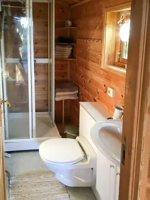 a bathroom with a toilet and a shower and a sink at Charming Artist's Cabin With Sea View Near Bergen in Straume
