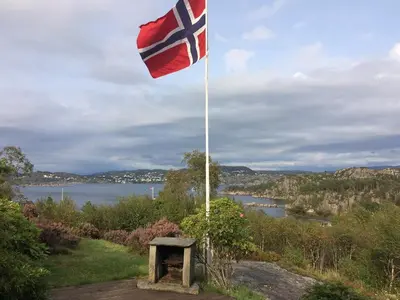 a flag on a flag pole with a view of a lake at Charming Artist's Cabin With Sea View Near Bergen in Straume