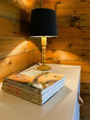 a lamp sitting on top of three books on a table at Cozy Holiday Home Embraced By Valdres Hills in Vang I Valdres
