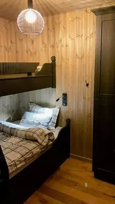 a bedroom with a bed with a wooden wall at Modern Cabin In Trysil With Mountain Views in Trysil