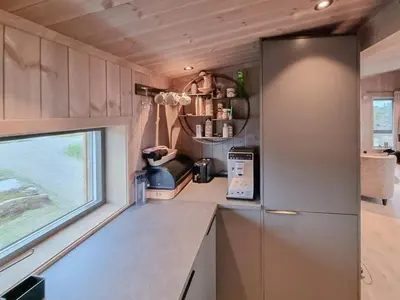 a kitchen with a refrigerator and a window at Stylish Modern Cabin In Charming Kvitfjell in Favang