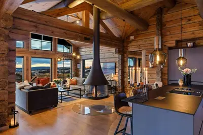 a kitchen and living room in a log cabin at Modern And Spacious Cabin At Mosetertoppen in Øyer