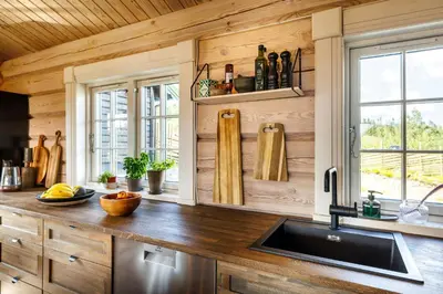 a kitchen with wooden walls and a counter with a sink at Cozy And Spacious Family Cabin In Valdres in Bagn